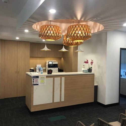 Contemporary office reception with wooden accents and stylish lighting.